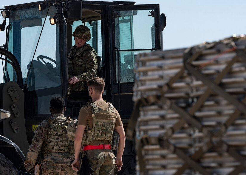 A photo of an Airman directing machinery