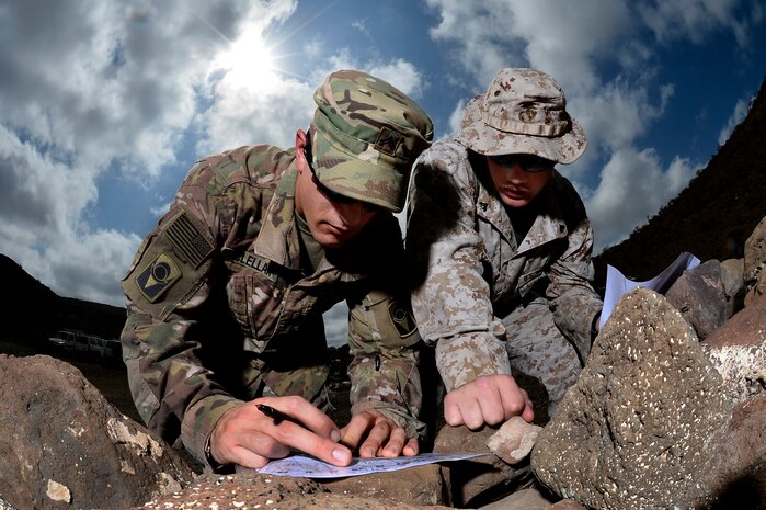 U.S. Army Cpl. Gregory McLellan and U.S. Marine Corps Cpl. Clinton Smith, Joint Corporals Leadership Development Course students, plot grid points during the land navigation portion of Camp Lemonnier's Joint Corporal’s Leadership Development Course at Arta, Djibouti, March 3, 2016. During the evaluation ‎Soldiers, ‎Sailors, ‎Airmen, and ‎Marines had to find eight different points and navigate to those points in a timed event. (U.S. Air Force photo by Tech. Sgt. Dan DeCook)