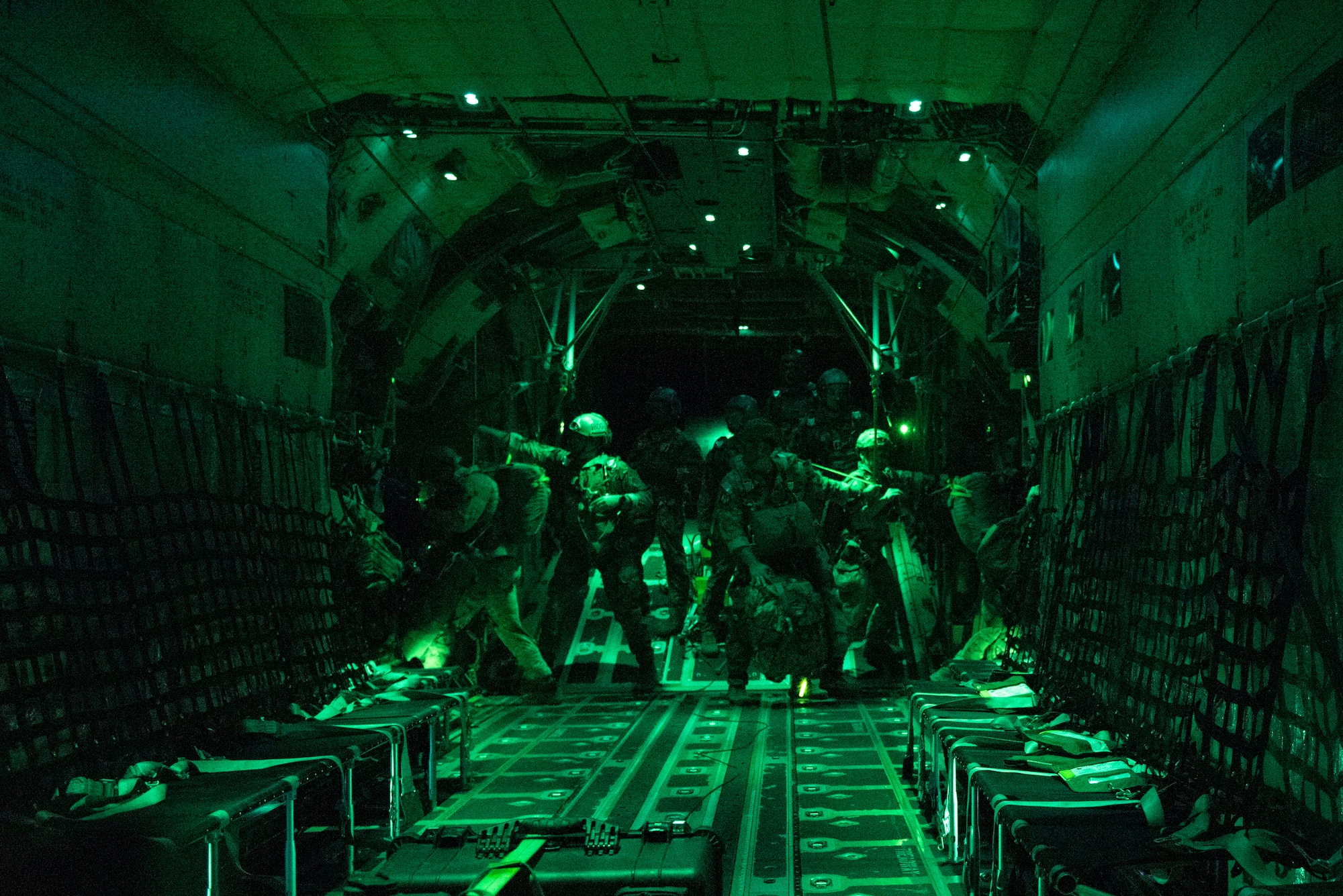 A photo of Airmen jumping out of an HC-130J Combat King II.