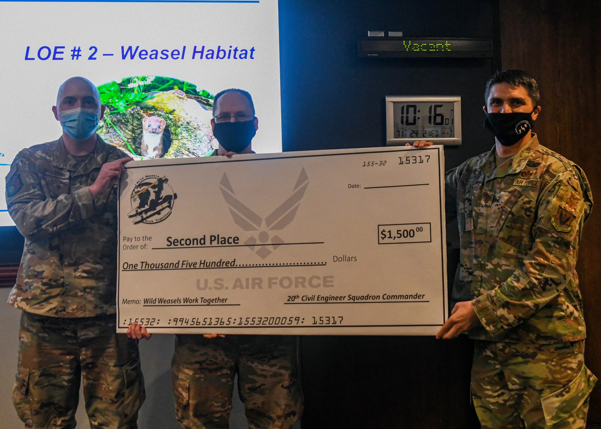 Photo of Airmen standing for a photo while being recognized