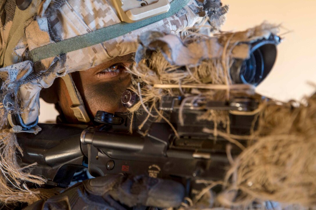 A Marine looks though the scope of a weapon.