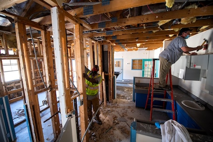 Samuel Burrell Sr., left, and Troy Cook, 502nd Civil Engineer Squadron maintenance mechanics, remove nails during the demolition phase of reconstruction Feb. 25, 2021, at Joint Base San Antonio-Lackland, Texas.