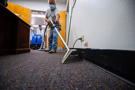 Joe Luna, right, and Rosendo Blanco, 502nd Civil Engineer Squadron maintenance mechanics, vacuum water in Freedom Chapel, Feb. 24, 2021, at Joint Base San Antonio-Lackland, Texas. The damage was caused by severe winter storm lasting over five days.