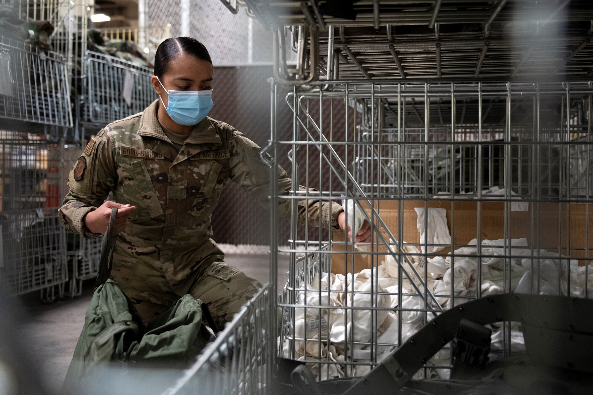 Senior Airman Genesis Robles-Rivas, a materiel manager in the 419th Logistics Readiness Squadron, selects glove inserts from a bin in preparation for training Feb. 7, 2021, at Hill Air Force Base, Utah.