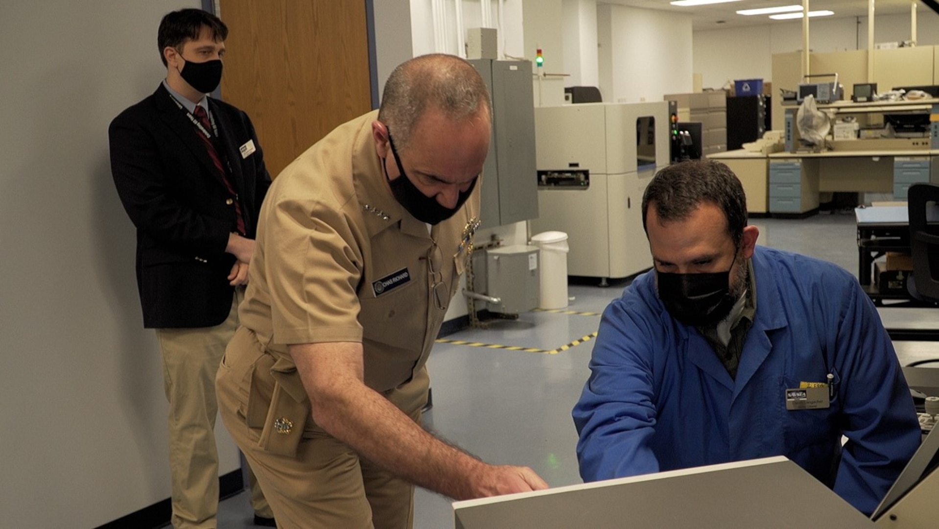 A Crane employee speaks with Strategic Command’s senior leader Adm. Charles Richard in a lab.