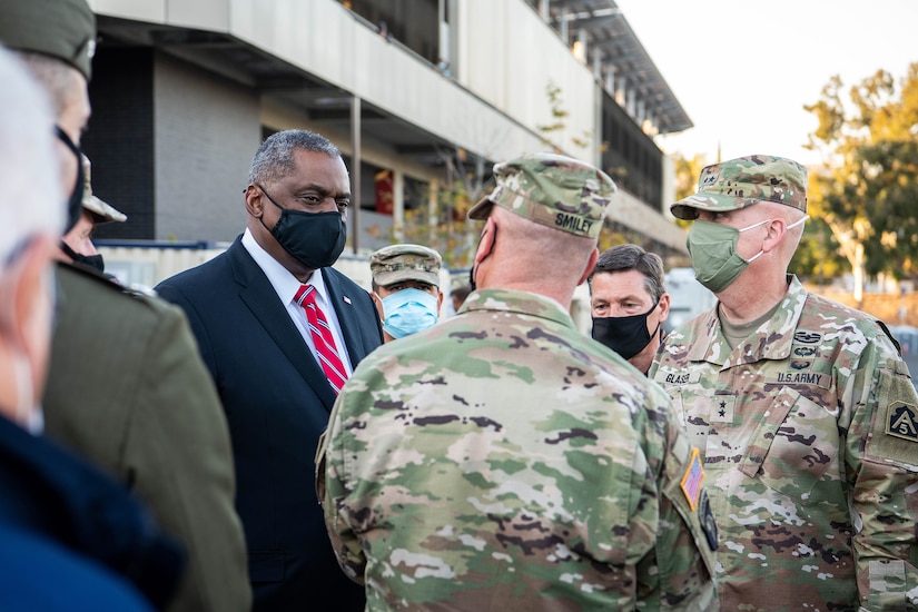 Secretary of Defense Lloyd J. Austin III speaks to service members outside a building.