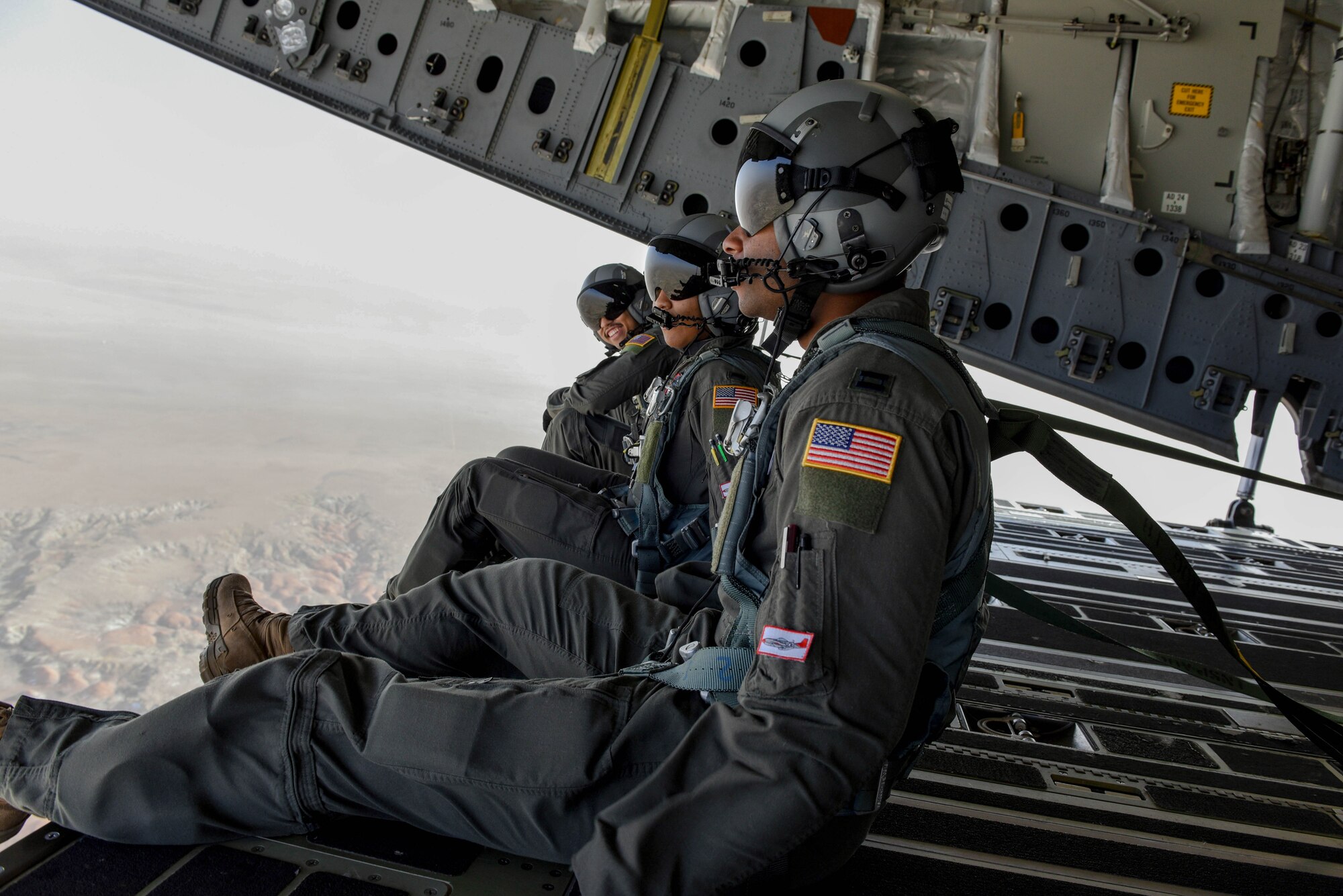 From right to left, Capt. Dre Davis, 8th Airlift Squadron pilot; 1st Lt. Erica Drakes, 4th Airlift Squadron pilot; and Airman 1st Class Tim McLaren, 8th Airlift Squadron loadmaster, watch from the back of C-17 Globemaster III during a low-level flight training exercise. During actual air-drop missions, the aircraft has to fly lower to the ground, which sometimes creates more turbulence and inconsistent wind. (U.S. Air Force photo by Senior Airman Mikayla Heineck)