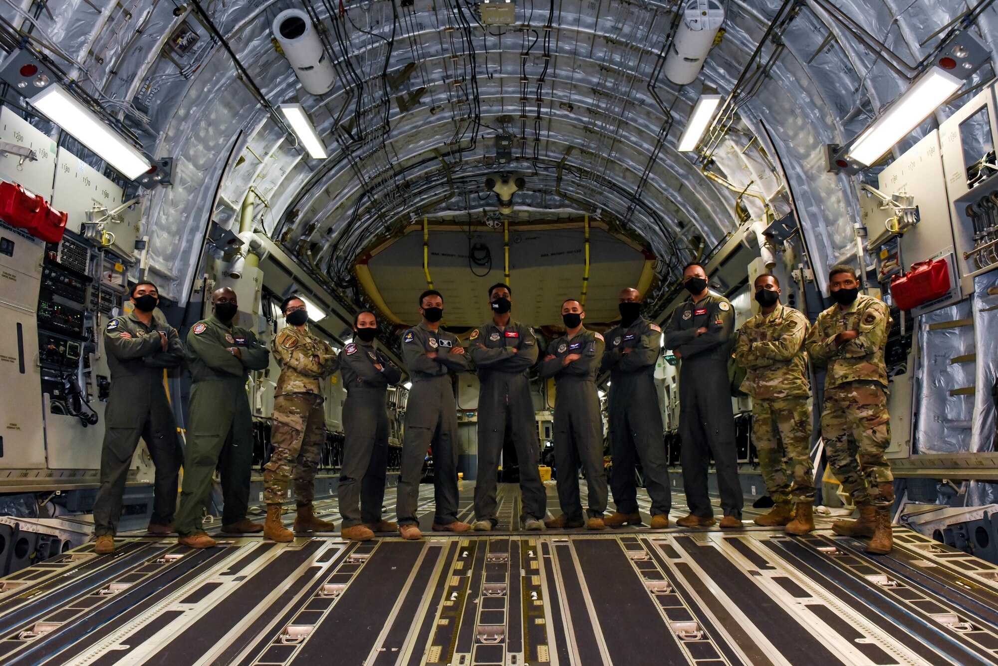 Eleven black air crew members from the 4th and 8th Airlift Squadrons, 62nd Operations Support Squadron, and the 62nd Aircraft Maintenance Squadron on Joint Base Lewis-McChord, Wash., pose at the back of a C-17 Globemaster III after completing a successful training flight and attending a heritage event for Black History Month, honoring the history and supporting the future of black Airmen. (U.S. Air Force photo by Senior Airman Mikayla Heineck)