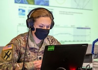 Lt. Col. Jennifer Green, a Joint Task Force Civil Support (JTF-CS) exercise planner, briefs the JTF-CS commanding general on simulated disaster response operations during a commander's update brief as part of a command post training exercise on Fort Bragg, N.C., Feb. 25, 2021.