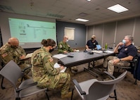 Joint Task Force Civil Support (JTF-CS) personnel, observer, controller, trainers with the 78th Training Division, and XVIII Airborne Corps Assistant Commanding General, Canadian Brig. Gen., Robert Ritchie, discuss training objectives and task force performance during a command post training exercise on Fort Bragg, N.C., Feb. 25, 2021.