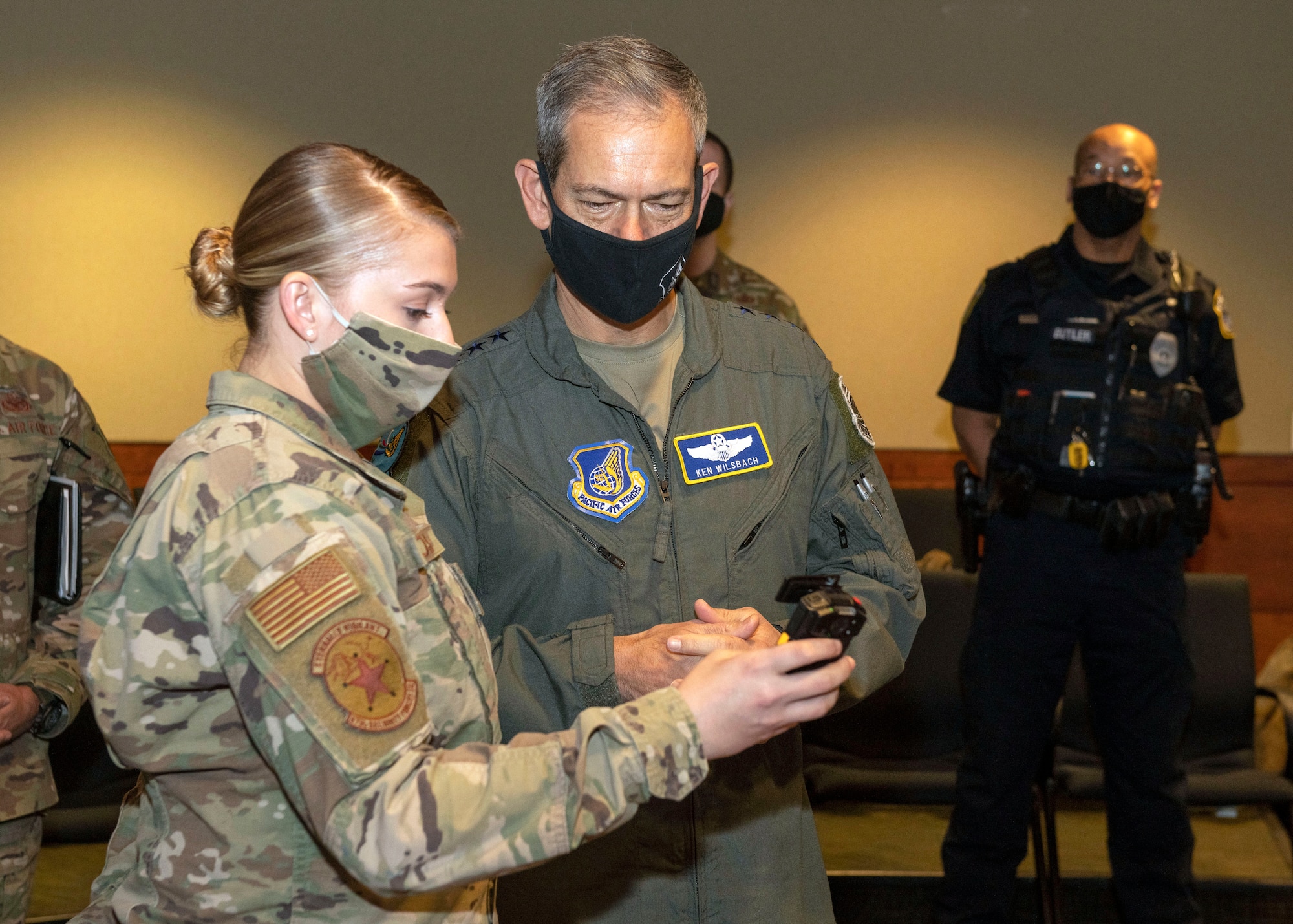 U.S. Air Force Senior Airman Danielle Chose, a police services specialist assigned to the 673d Security Forces Squadron, briefs U.S. Air Force Gen. Kenneth Wilsbach, the Pacific Air Forces commander, on the 673d SFS’ new body cameras at Joint Base Elmendorf-Richardson, Alaska, Feb. 16, 2021. PACAF leadership conducted an immersion tour of JBER to learn about the installation's role in readiness and defense in the Arctic as well as focusing on how the base remains postured for the future through innovative ideas.