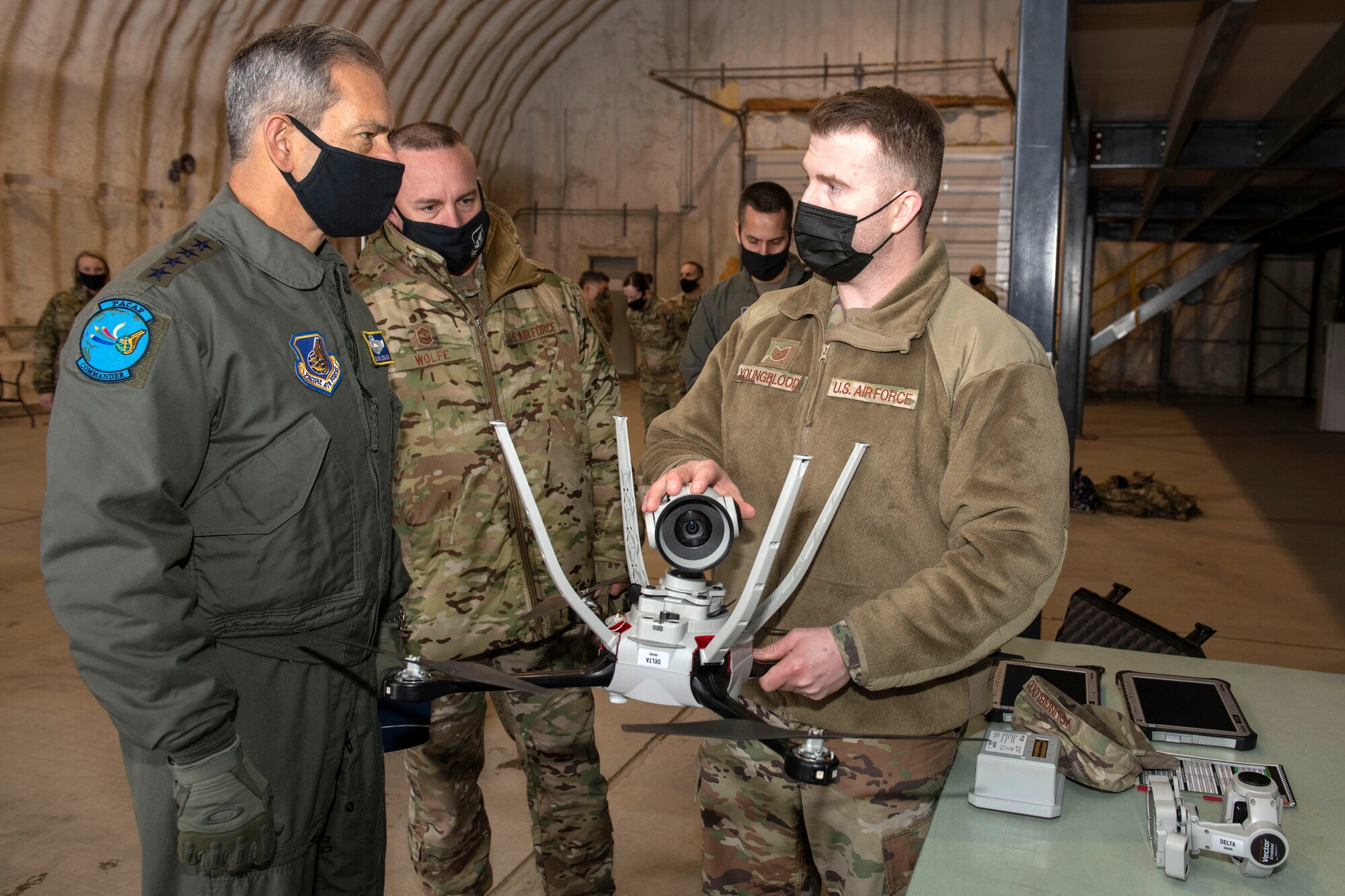 U.S. Tech. Sgt. Matthew Youngblood, right, the Small Unmanned Aircraft System program manager assigned to the 773d Civil Engineer Squadron, briefs U.S. Air Force Gen. Kenneth Wilsbach, left, the Pacific Air Forces commander, and U.S. Air Force Chief Master Sgt. David Wolfe, center, the Pacific Air Forces command chief, on the 773d CES’ SUAS program at Joint Base Elmendorf-Richardson, Alaska, Feb. 16, 2021. PACAF leadership conducted an immersion tour of JBER to learn about the installation's role in readiness and defense in the Arctic as well as focusing on how the base remains postured for the future through innovative ideas.