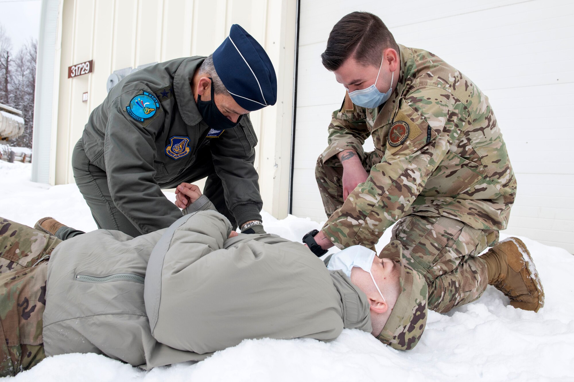 U.S. Air Force Staff Sgt. Colin Mullaly, right, an independent duty medical technician assigned to the 673d Medical Group, assists U.S. Air Force Gen. Kenneth Wilsbach, left, the Pacific Air Forces commander, with a tourniquet to show the need for the 673d MDG’s Below Zero Medicine program at Joint Base Elmendorf-Richardson, Alaska, Feb. 16, 2021. PACAF leadership conducted an immersion tour of JBER to learn about the installation's role in readiness and defense in the Arctic as well as how the base remains poised for the future through innovative ideas.