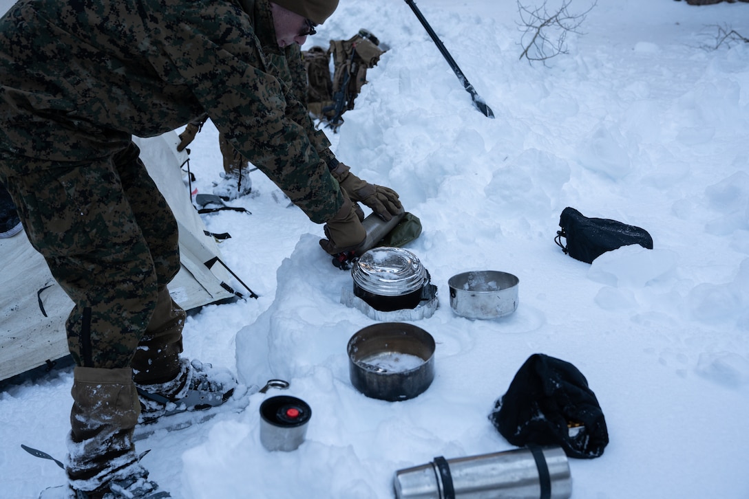A Marine with 2nd Battalion, 7th Marines turns on a white gas stove while melting snow at the Mountain Warfare Training Center, on January 30, 2021. Marines participated in the Mountain Training Exercise, which prepares units for offensive operations in mountainous environments. (U.S. Marine Corps photo by Lance Cpl. Andrew R. Bray)