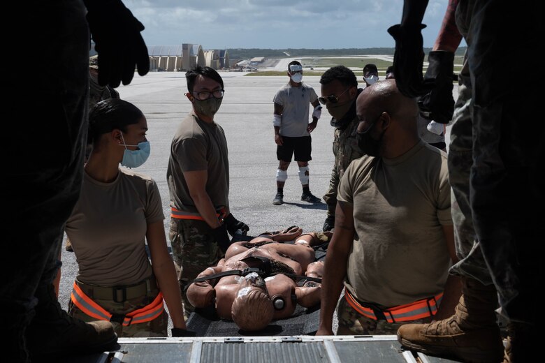 U.S. Air Force Airmen with the 36th Medical Group prepare to lift a patient into a bus for transport to a proper medical facility during an exercise at Andersen Air Force Base, Guam, Feb. 10, 2021.