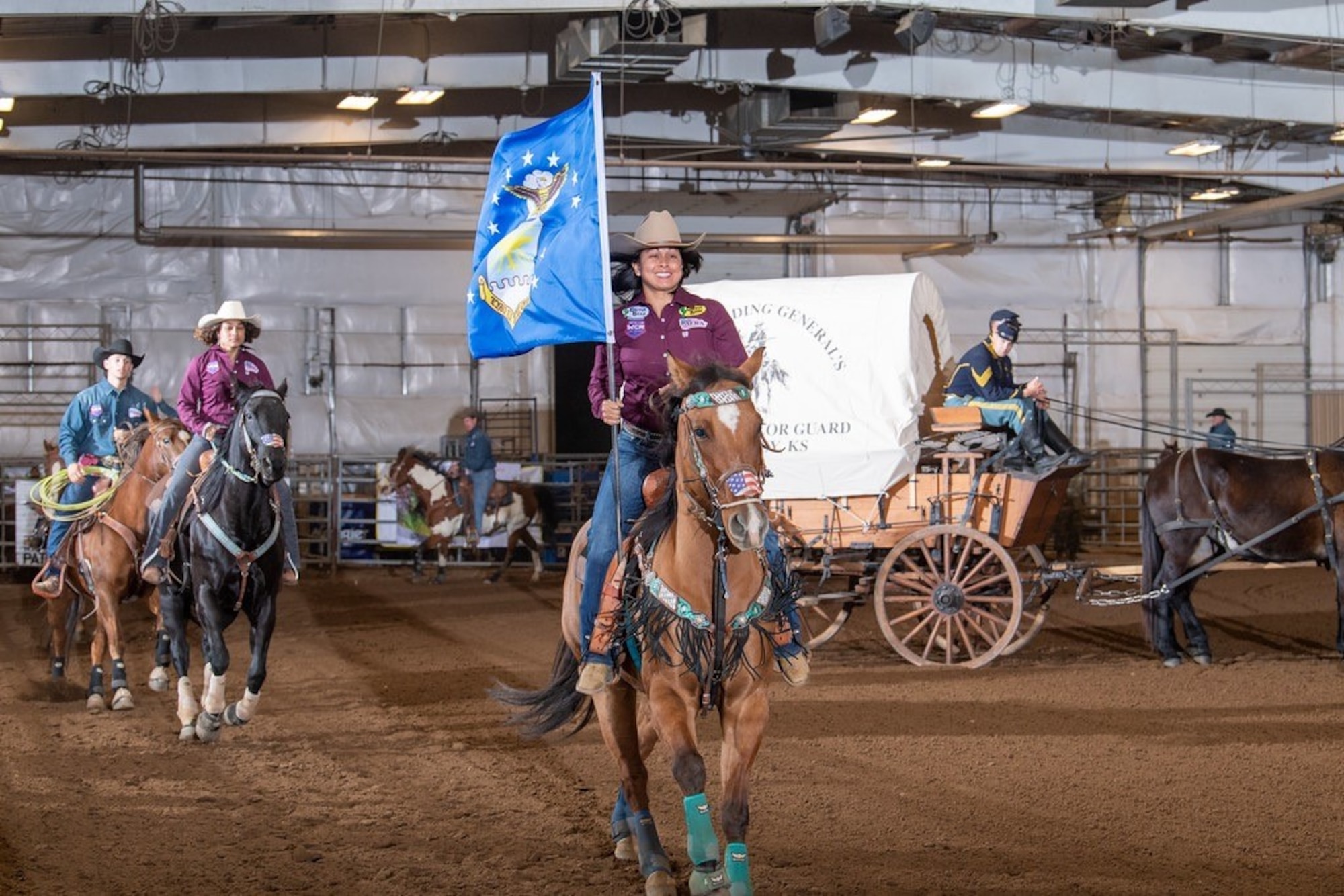 Master Sgt. Jenniffer Teets, 436th Comptroller Squadron, carries the Air Force flag while on horseback during a rodeo competition. (Courtesy photo)