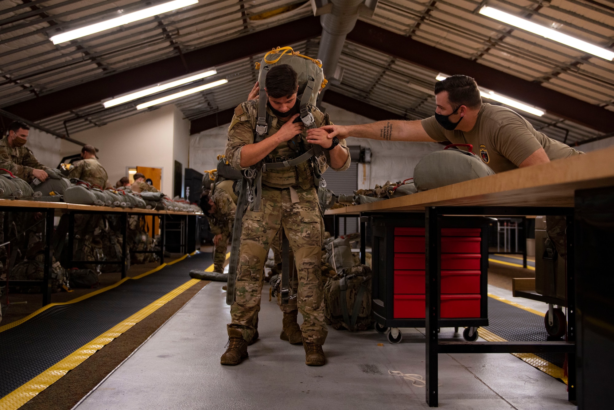 A photo of an Airman donning a parachute.