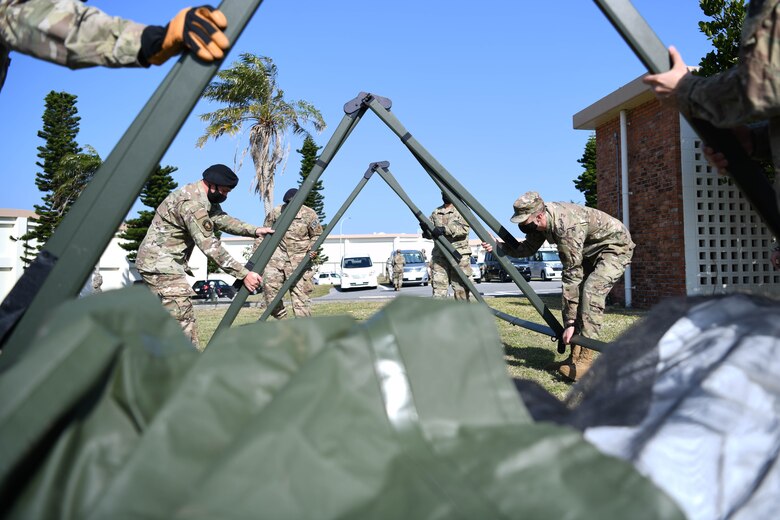 U.S. service members from the 18th Wing practice assembling a multi-use tent during a Multi-Capable Airmen course exercise, at Kadena Air Base, Japan, Feb. 24, 2021. This training is a part of the “beddown procedures” portion of the course, preparing Airmen to set up facilities in any location necessary.