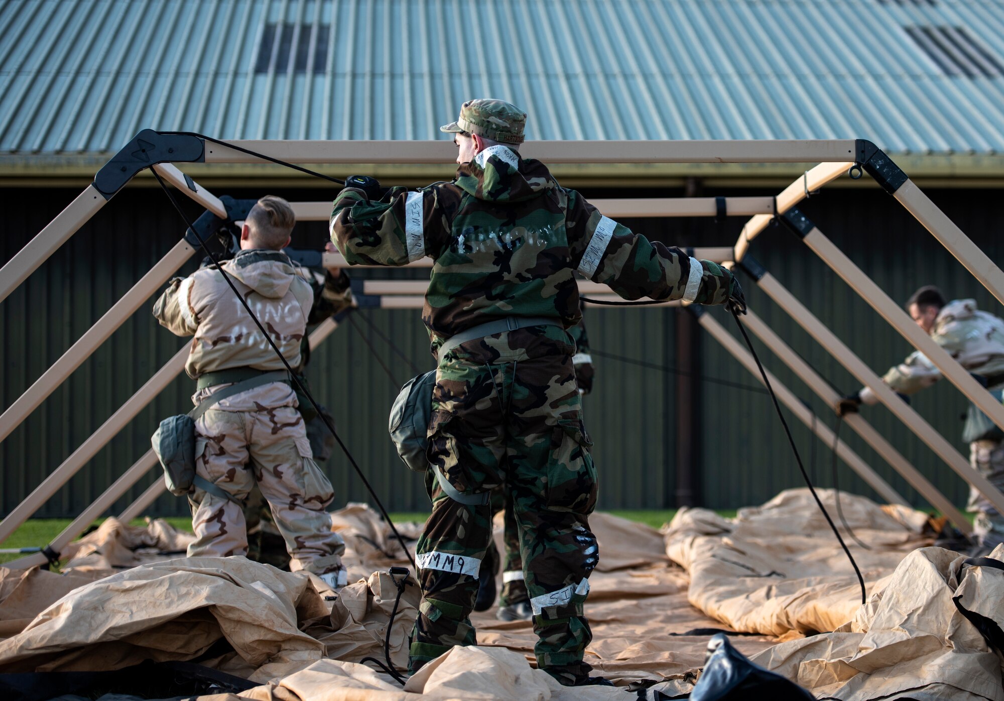 U.S. Air Force Airmen assigned to the 48th Civil Engineering Squadron set up a tent during a readiness training event at Royal Air Force Feltwell, Nov. 4, 2020. The monthly training serves to enhance and maintain response to real-world scenarios through teamwork and practical application. (U.S. Air Force photo by Airman 1st Class Jessi Monte)