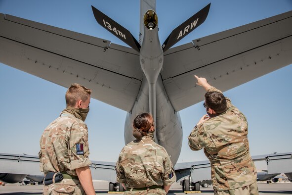 a pilot conducts a preflight inspection of an aircraft with royal air force members