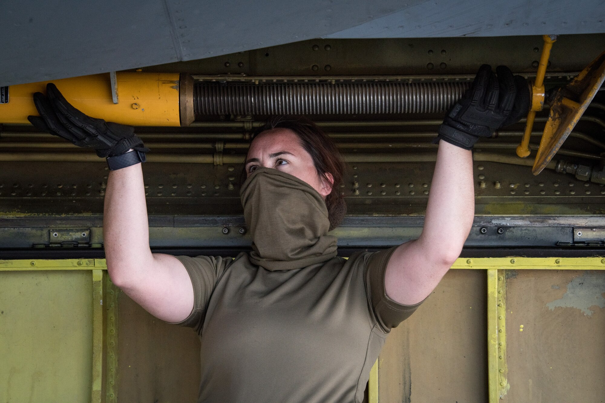 Royal Air Force member loads a boom support jack into a storage compartment