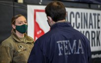 U.S. Army Lt. Col. Angela Lacek, the 90th Medical Operations Squadron flight commander, speaks with a Federal Emergency Management Agency employee at the state-run, federally-supported Medgar Evers College COVID Community Vaccination Center in Brooklyn, N.Y., Feb. 22, 2021.
