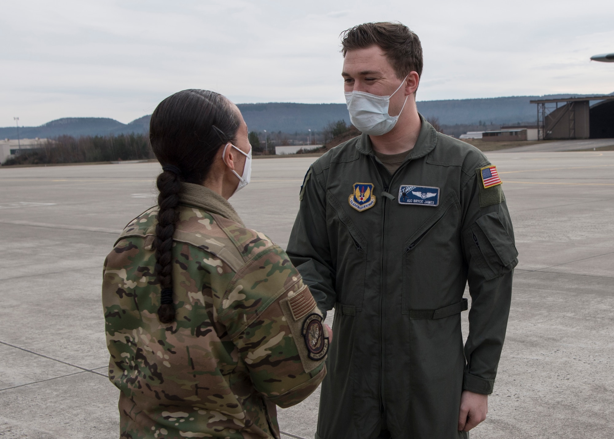 Two Airmen standing on an airfield.