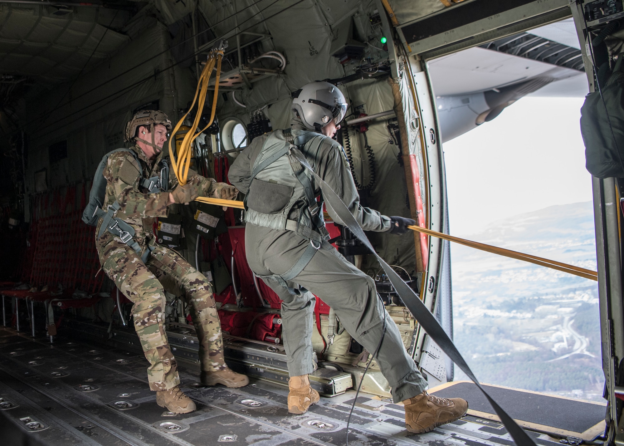 Airmen pulling static line back into aircraft.