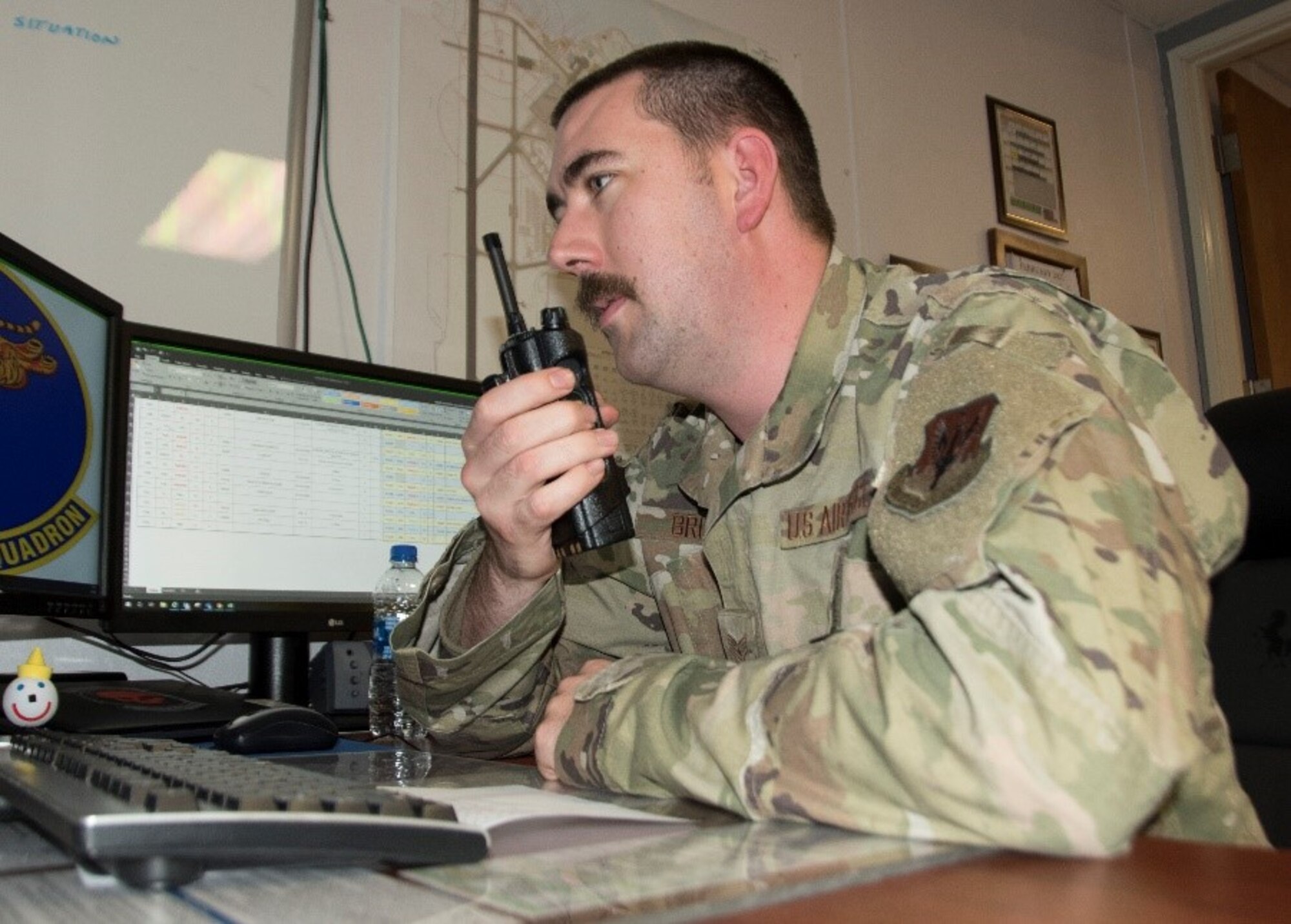 U.S. Air Force Staff Sgt. Matthew Brown, 24th Fighter Squadron maintenance operations center production controller, communicates over a radio at U.S. Naval Air Station Joint Reserve Base Fort Worth, Texas, Feb. 5, 2021. Production controllers relay information, such as status changes, to expediters on the flightline. (U.S. Air Force photo by Kedesha Pennant)