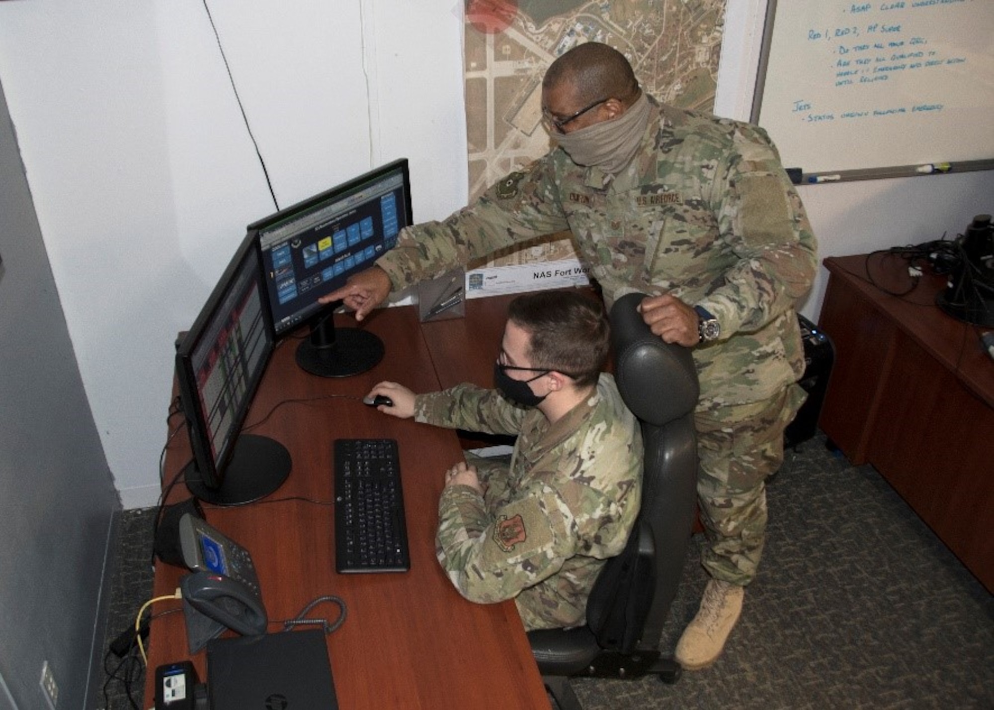 (right) Tech. Sgt. Anthony Crayton, 301st Fighter Wing Maintenance Group maintenance operations center production lead, points at the fly tracker while instructing Tech. Sgt. Jason Dover, 301 FW MXG MOC production controller, at U.S. Naval Air Station Joint Reserve Base Fort Worth, Texas, Feb. 5, 2021. The fly tracker traces the flying status for the F-16 Fighting Falcon. (U.S. Air Force photo by Kedesha Pennant)