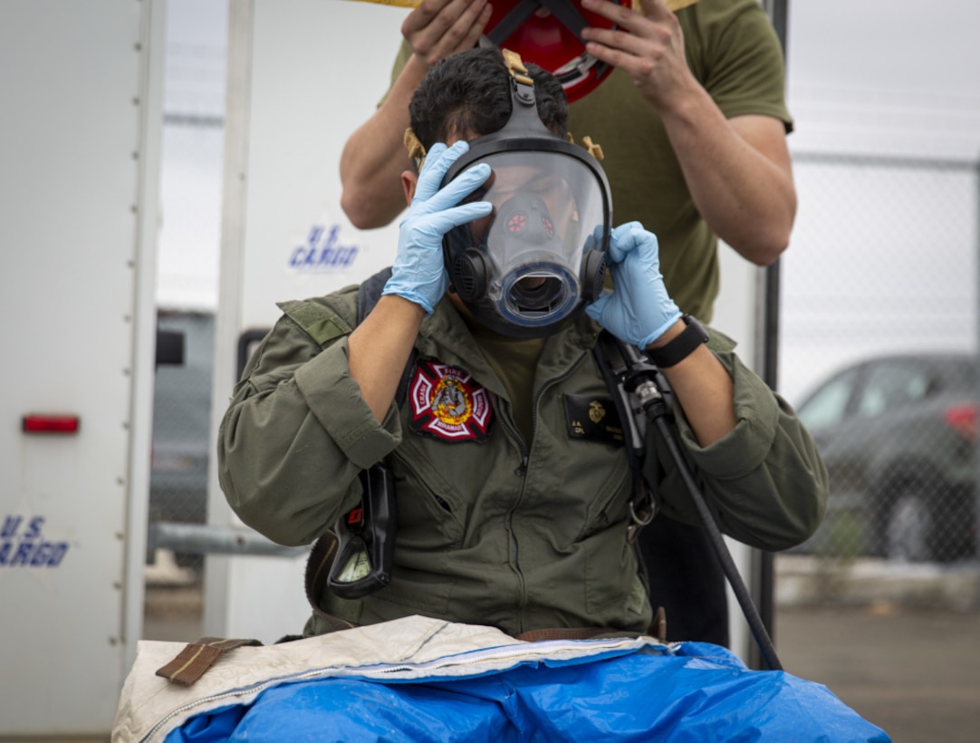 U.S. Marine Corps Cpl. Jose Salcedo, an Aircraft Rescue and Firefighting Marine with Headquarters and Headquarters Squadron, Marine Corps Air Station Miramar, puts on a gas mask during hazardous materials training at MCAS Miramar, San Diego, California, Feb. 1, 2021. The training reinforced MCAS Miramar's readiness incase of a HAZMAT emergency. (U.S. Marine Corps photo by Lance Cpl. Krysten Houk)