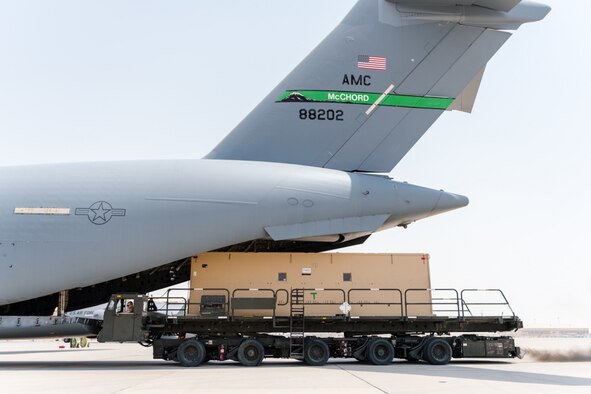 U.S. Air Force Airmen assigned to the 8th Expeditionary Air Mobility Squadron offload a Negatively Pressurized Conex-Lite from a C-17 Globemaster III at Al Udeid Air Base, Qatar, Aug. 3, 2020. The NPC-Lite is an isolated containment chamber designed to transport individuals with infectious diseases, such as COVID-19. (U.S. Air Force photo by Staff Sgt. Lauren Parsons)