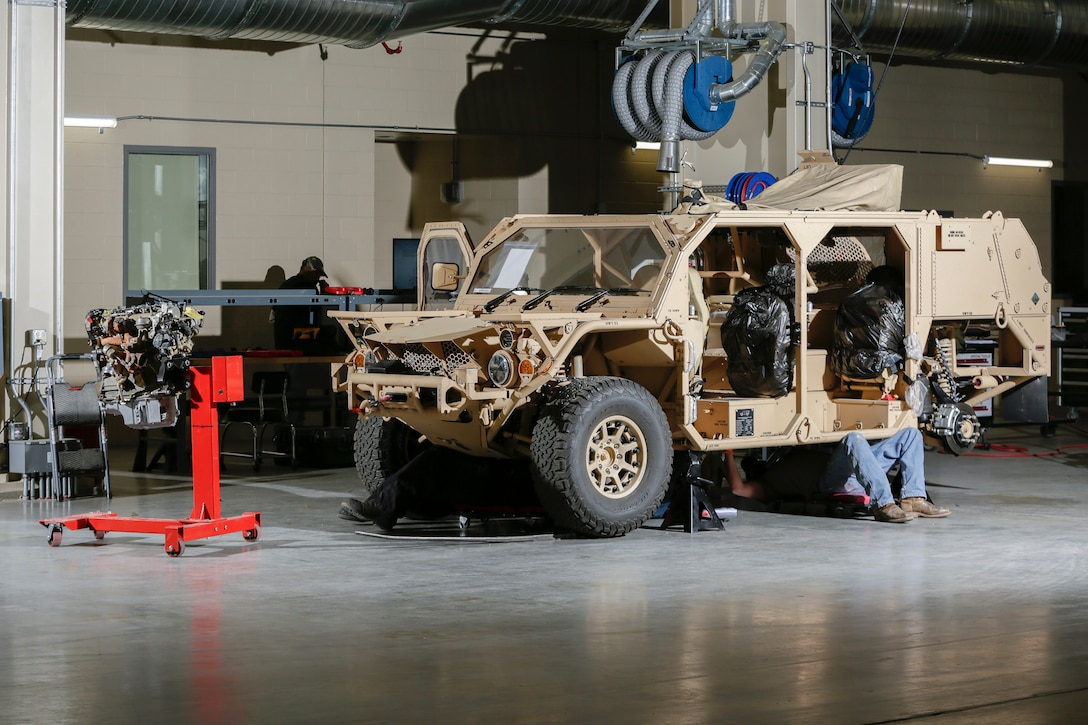 Heavy Mobile Equipment mechanics work with Flyer Defense personnel to learn every aspect of maintenance and repair of the Special Operations' Ground Mobility Vehicle at Production Plant Barstow, Marine Depot Maintenance Command, aboard the Yermo Annex of Marine Corps Logistics Base Barstow, Feb 24.