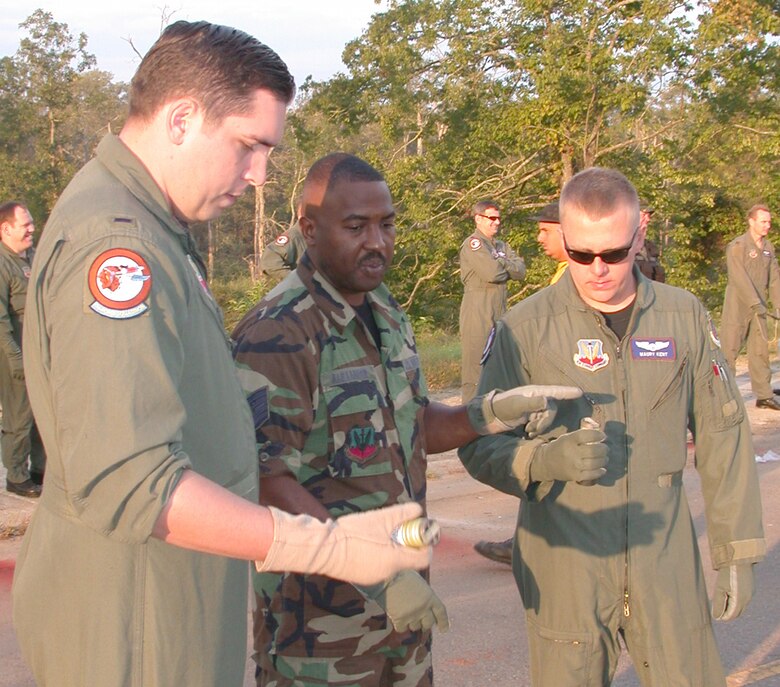 Photo of Airmen looking down at smoke bombs.