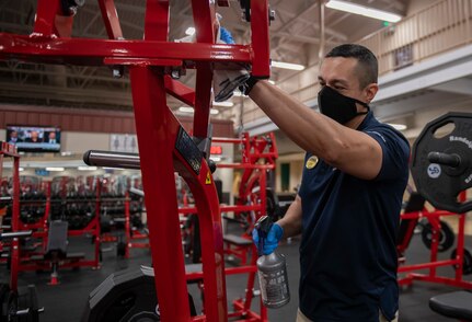Armando Torres, 502nd Force Support Squadron recreational aide, cleans exercise equipment at Rambler Fitness Center.