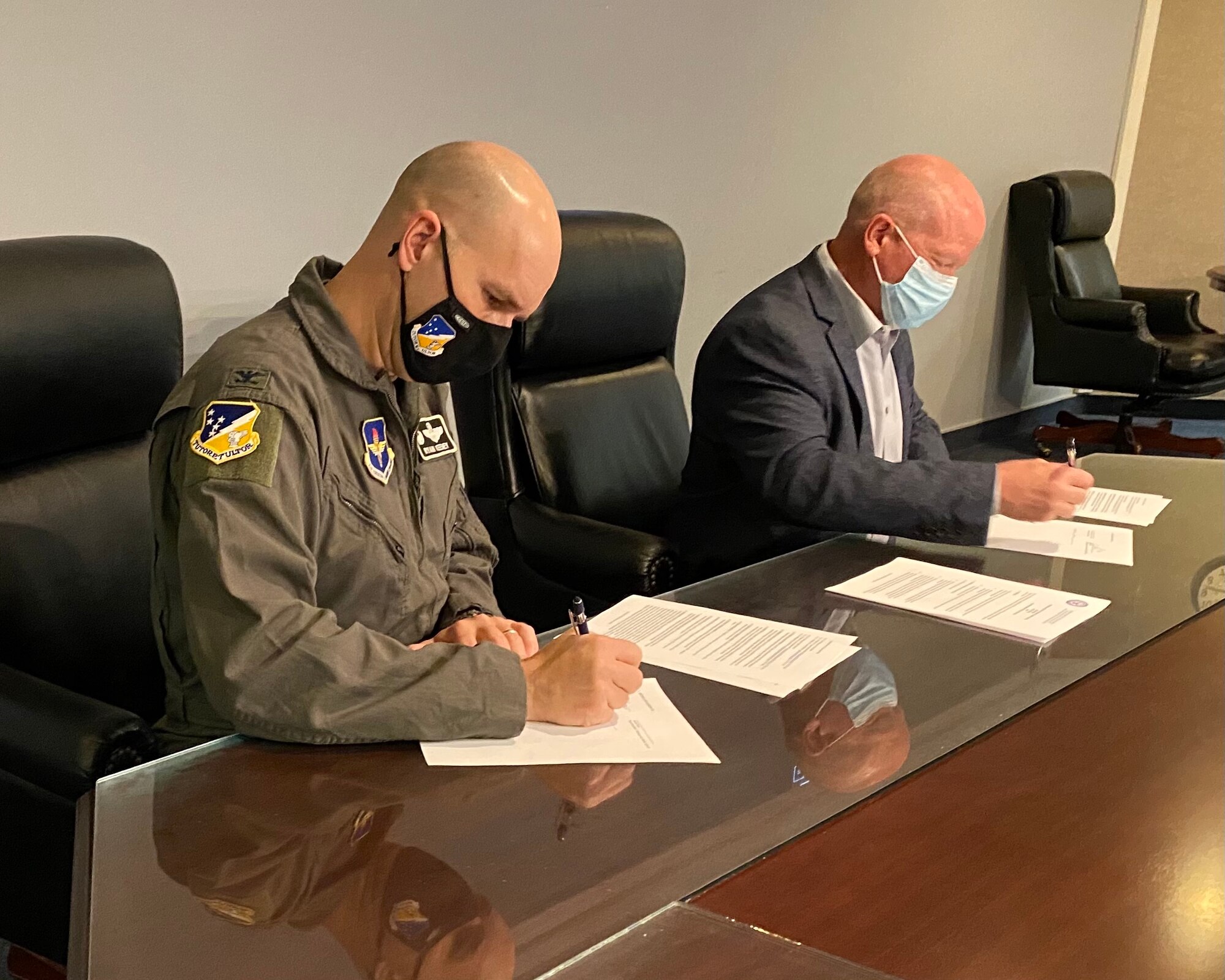 Col. Ryan Keeney, left, 49th Wing commander, and Jerrett Perry, Alamogordo Public School superintendent, sign a memorandum for Project SEARCH, Feb. 24, 2021, on Holloman Air Force Base, New Mexico. Project SEARCH is a high school transition-to-work program that serves young people with developmental disabilities to ensure successful transitions to productive adult life. (Courtesy photo)