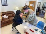 Missouri Army National Guard Staff Sgt. Jeremy Brown, 1107th TASMG, being interviewed by Emma Hogg of KMOV at a targeted vaccination team site in St. Louis on February 24, 2021.