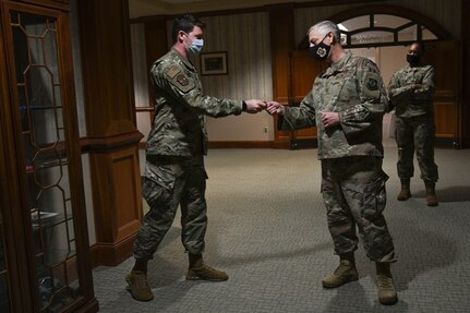 Airman 1st Class David Jenkins, from the 628th Comptroller Squadron,  gets coined by Maj. Gen. Mark Camerer, U.S. Air Force Expeditionary Center commander, at Joint Base Charleston, S.C., Feb. 9, 2021. Camerer, along with Chief Master Sgt. Anthony W. Green, USAF Expeditionary Center command chief, toured the base to get a firsthand look at Team Charleston’s capabilities and accomplishments.