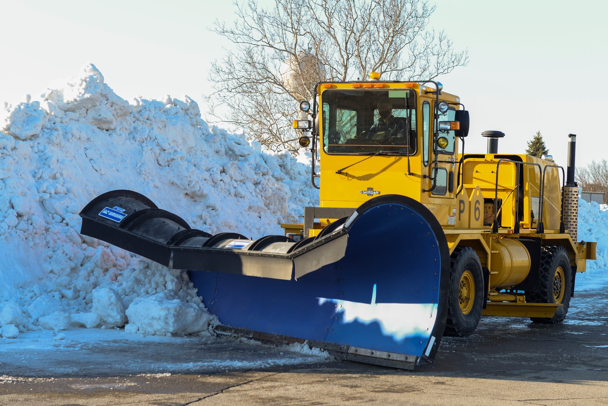 A plow with the 88th Civil Engineer Squadron snow removal team pushes snow into a snow pile on the airfield of Wright-Patterson Air Force Base, Ohio, Feb. 23, 2020. From November to April the team runs 24-hour operations with as many as 30 pieces of equipment to ensure the mission of Wright-Patt can continue.