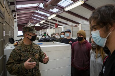 U.S. Marine Corps poolees from Recruiting Sub-Station Oceanside take a tour of the military working dog kennels as part of a Marine Corps recruiting pool function on Marine Corps Air Station Miramar, San Diego, California, Feb. 13, 2021. The Miramar Provost Marshal's Office hosted a MWD demonstration for Recruiting Sub-Station Oceanside poolees in order to educate them about life as a MWD handler. (U.S Marine Corps photo by Cpl. Andrew Hiatt)