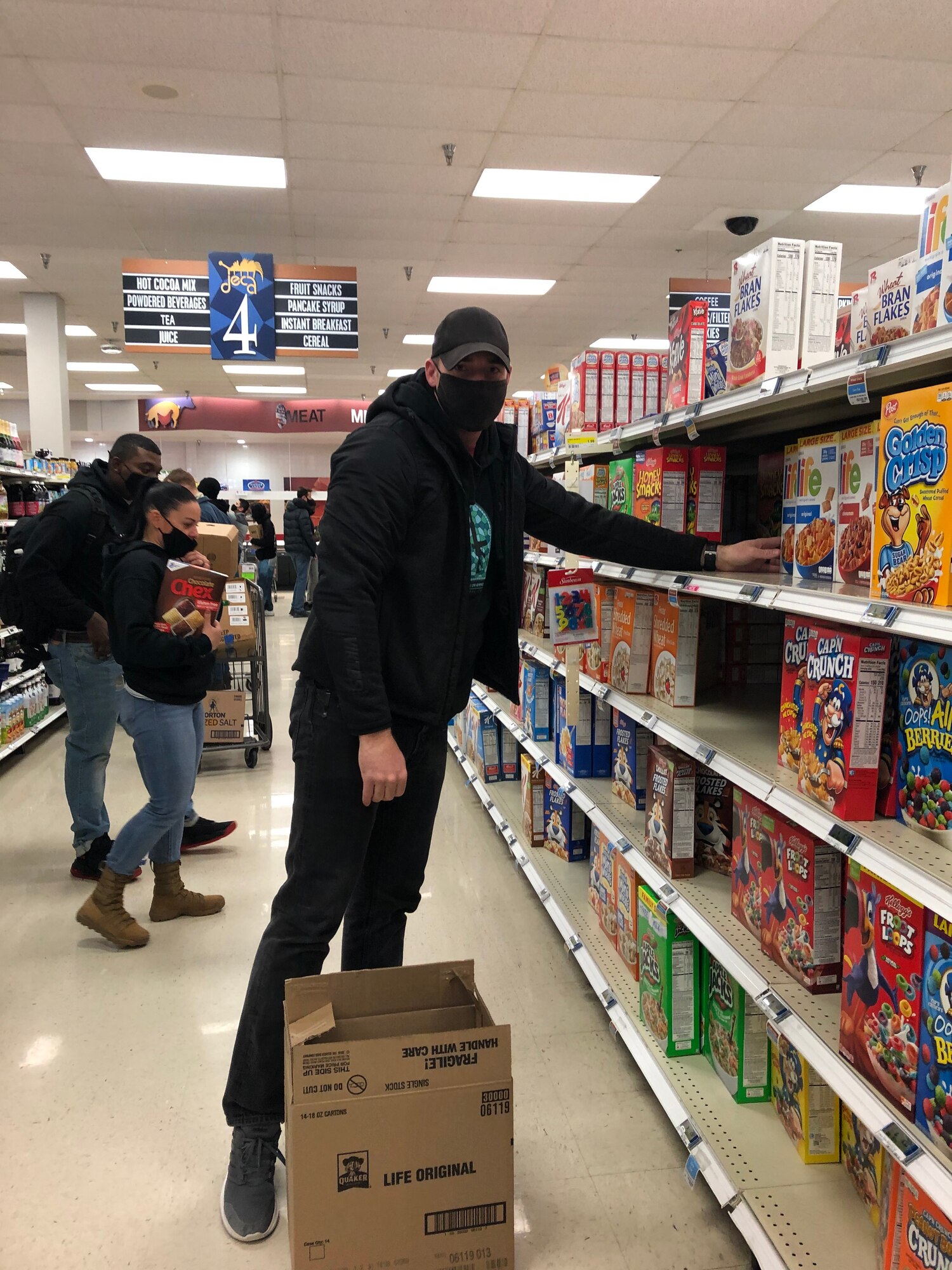 A volunteer stocks a shelf with dry cereal in the commissary on Goodfellow Air Force Base, Texas, Feb. 17, 2021. Winter Storm Uri increased the demand for nonperishable items and left shelves empty. (Courtesy photo)