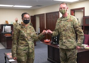 Airman receives coin from commander