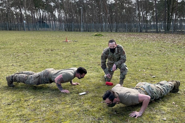 From left, U.S. Air Force Senior Airman Kevin Stiger, 701st Munitions Support Squadron custody forces specialist, Tech. Sgt. Gabriel Solazzo, 701st MUNSS NCO in charge of plans and programs, and Senior Airman Chase DuPont, 701st MUNSS nuclear weapons technician, begin security forces augmentee training hosted on Kleine Brogel Air base, Blegium, Feb. 26, 2021. In the baton portion of training, the participants started their exercises by accelerating their heart rate with push-ups, before baton sparring with an opponent. (Courtesy photo)