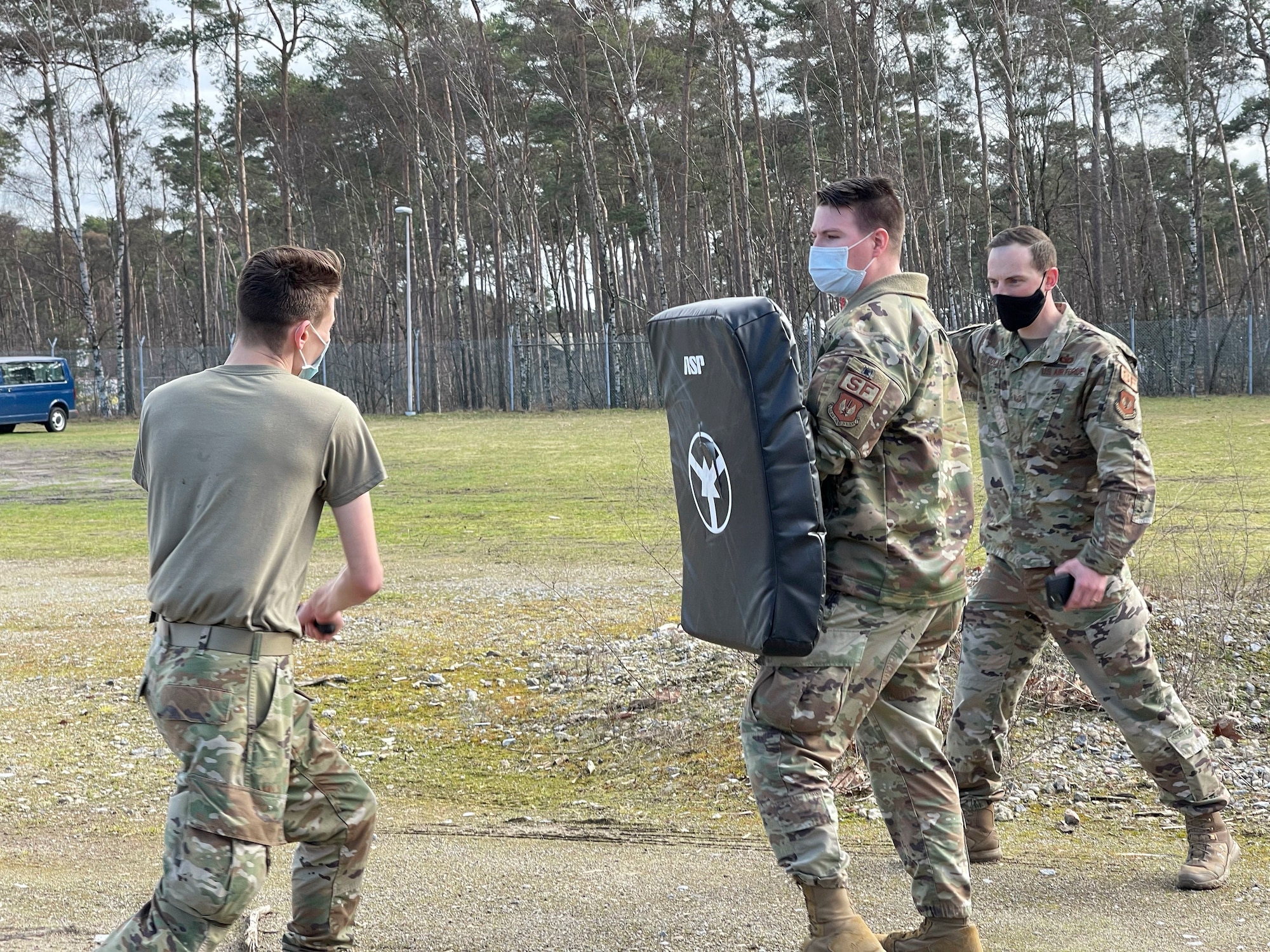 From left, U.S. Air Force Senior Airman Calvin Kelly, 701st Munitions Support Squadron weapons maintenance technician, Staff Sgt. Brent Mercado, 701st MUNSS custody forces specialist, and Tech. Sgt. Gabriel Solazzo, 701st MUNSS NCO in charge of plans and programs, engage in security forces augmentee training hosted on Kleine Brogel Air Base, Belgium, Feb. 26, 2021. Instructors and participants in this course maintained COVID-19 restrictions by wearing face masks, as well as maintaining physical distancing when possible. (Courtesy Photo)