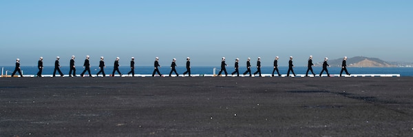 Sailors man the rails on the flight deck of the aircraft carrier USS Nimitz (CVN 68).