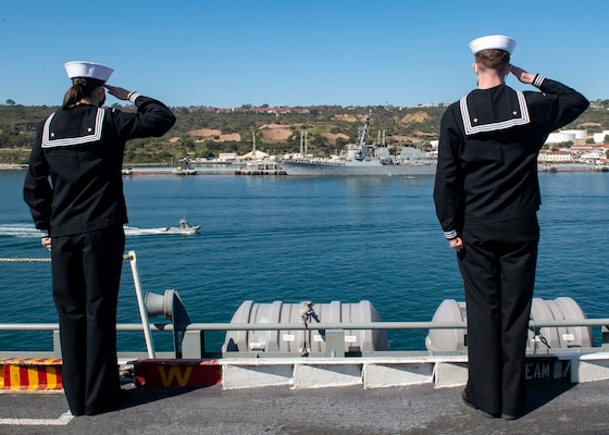 Sailors render honors to a passing vessel aboard the aircraft carrier USS Nimitz (CVN 68) to the Arleigh Burke-class destroyer, USS Howard (DDG 83).