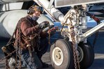210228-N-OB471-1005 ATLANTIC OCEAN (Feb. 28, 2021) Aviation Machinist's Mate Airman Brandon Luna, from Miami, breaks down chains for an F/A-18E Super Hornet, attached to the "Gunslingers" of Strike Fighter Squadron (VFA) 105, aboard the Nimitz-class aircraft carrier USS Dwight D. Eisenhower (CVN 69), in the Atlantic Ocean, February 28, 2021. Ike is on a routine deployment supporting U.S. national security interests in Europe and increasing theater cooperation and forward naval presence in the U.S. 6th fleet area of operations. (U.S. Navy photo by Mass Communication Specialist Seaman Jacob Hilgendorf/Released)