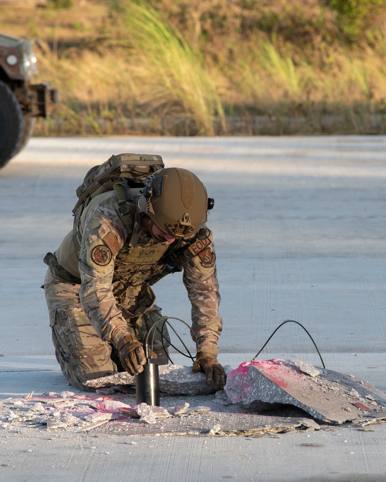 A U.S. Air Force Explosive Ordnance technician plants an explosive during a Rapid Airfield Damage Repair (RADR) Exercise at Andersen Air Force Base, Feb. 12, 2021.