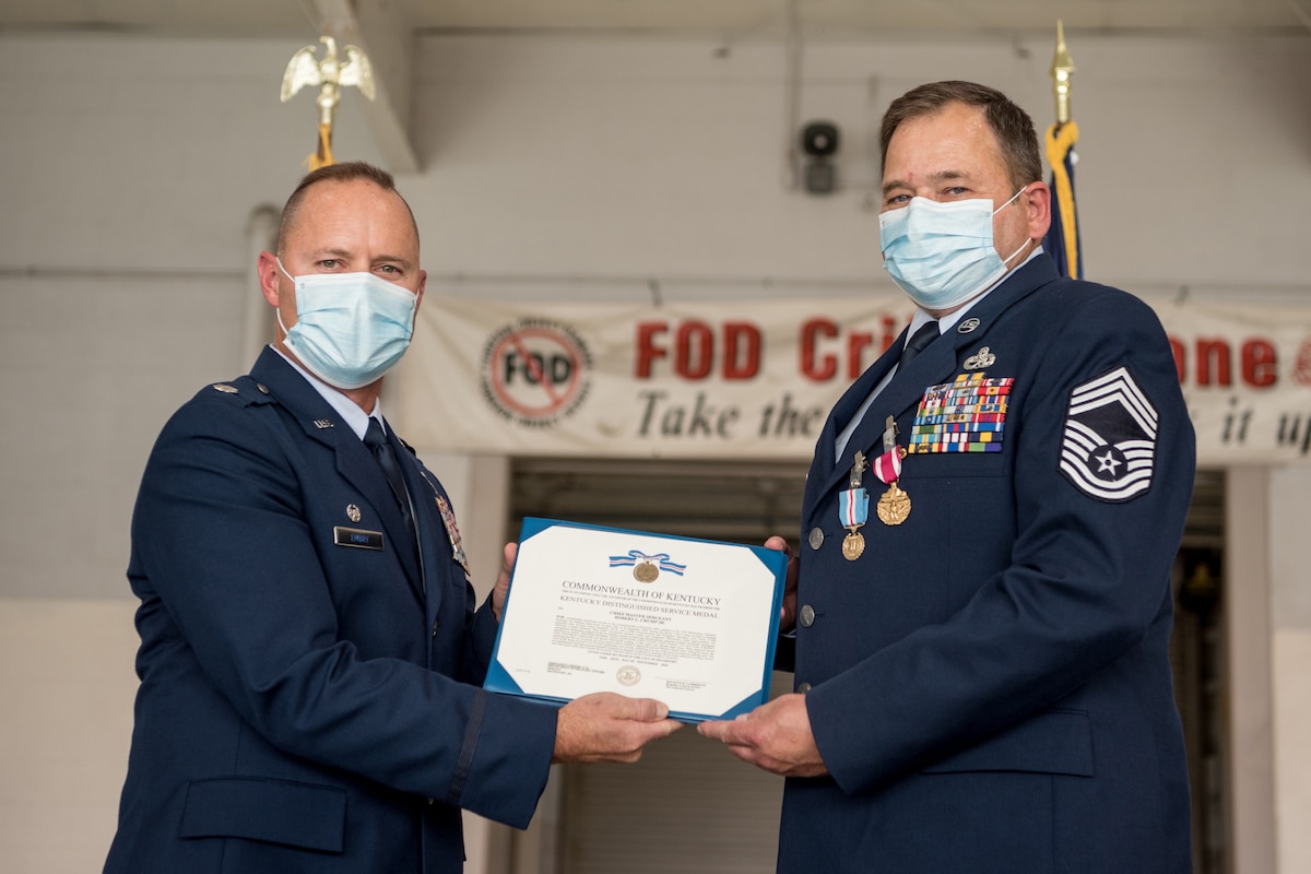 Chief Master Sgt. Robert Crump (right), outgoing equipment maintenance superintendent for the 123rd Maintenance Group, receives the Kentucky Distinguished Service Medal from Lt. Col. James Embry, commander of the 123rd Maintenance Group, during Crump’s retirement ceremony at the Kentucky Air National Guard Base in Louisville, Ky., Sept. 13, 2020. Crump is retiring after more than 39 years of service to the Kentucky Air National Guard. (U.S. Air National Guard photo by Staff Sgt. Joshua Horton)