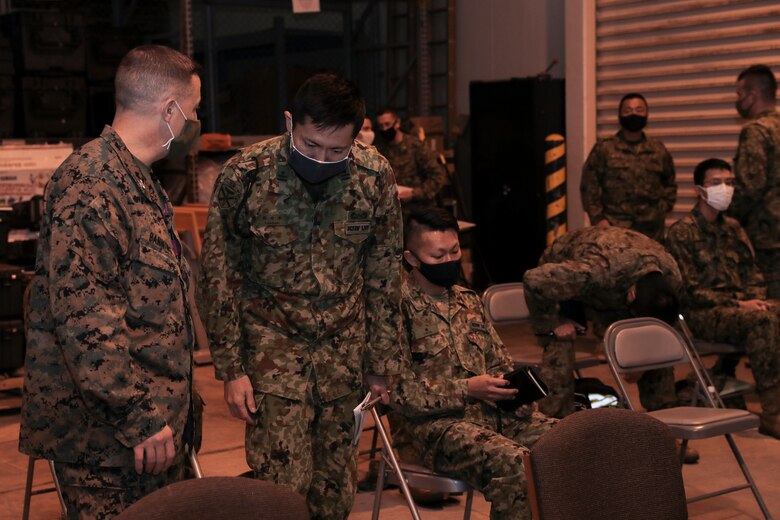 U.S. Marine Col. David Banning, the commanding officer of Marine Rotational Force-Darwin, speaks with a member of the Amphibious Rapid Deployment Brigade of the Japan Ground Self-Defense Force talk before a rehearsal of concept drill for Exercise Yama Sakura 79 at Camp Courtney, Okinawa, Japan, Dec. 5, 2020.
